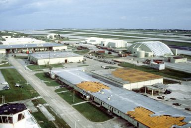 Overview of Anderson AFB flight line, with damaged roofs and battered hangers