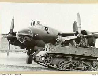 NEW GUINEA, 1942-08-11. PERSONNEL OF THE 39TH INFANTRY BATTALION, AUSTRALIAN MILITARY FORCES, IN THEIR BREN GUN CARRIER PAY A VISIT TO THE CREW OF AN AMERICAN B-26 BOMBER AS IT STANDS BY ON A NEW ..