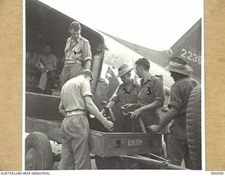 PORT MORESBY, NEW GUINEA. 1943-11-15. TROOPS OF THE 2/5TH AUSTRALIAN FIELD REGIMENT LOADING A DISMANTLED 25-POUNDER GUN INTO A DOUGLAS AIRCRAFT. SHOWN ARE: NX23300 GUNNER A.G. DUVAL (1); NX14769 ..