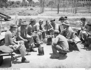 HOSKINS, NEW BRITAIN. 1944-10-09. TROOPS OF THE 125TH AUSTRALIAN GENERAL TRANSPORT COMPANY AND THE 40TH INFANTRY DIVISION, UNITED STATES ARMY, GET TOGETHER FOR A YARN IMMEDIATELY AFTER THEIR BEACH ..