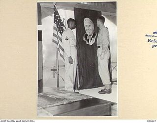 TOROKINA, BOUGAINVILLE. 1945-04-15. AN AMERICAN CORPORAL AND AN AUSTRALIAN SOLDIER IN THE CHAPEL STANDING BESIDE A PICTURE OF THE LATE PRESIDENT OF THE US, FRANKLIN DELANO ROOSEVELT. A MEMORIAL ..