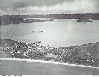 PORT MORESBY, PAPUA. 1932-09-17. AERIAL VIEW OF THE HARBOUR FACING NORTH WEST. NOTE THE COUNTY CLASS CRUISER AT ANCHOR. (NAVAL HISTORICAL COLLECTION)