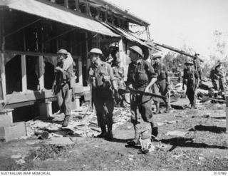 1943-09-22. NEW GUINEA. AUSTRALIAN TROOPS CAPTURE LAE. AUSTRALIAN TROOPS INSPECT SHATTERED BUILDINGS AT LAE