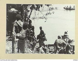 BOUGAINVILLE AREA. 1945-01-22. NATIVE WOMEN AND CHILDREN WHO HAVE BEEN RESCUED FROM THE JAPANESE IN THE SOUTHERN BOUGAINVILLE AREA BEING PLACED ABOARD BARGES FOR TRANSPORT TO THE MOUTH OF THE JABA ..