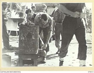 MILILAT, NEW GUINEA. 1944-06-19. AUSTRALIAN ARMY SERVICE CORPS PERSONNEL OF HEADQUARTERS, 5TH DIVISION HELPING THEMSELVES TO A CUP OF TEA AT THE SALVATION ARMY RED SHIELD HUT. IDENTIFIED IS Q270458 ..