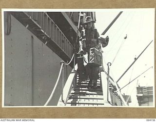 TOWNSVILLE, QLD. 1944-01-28. PERSONNEL OF THE 24TH INFANTRY BRIGADE PROCEEDING DOWN THE GANGWAY OF THE TROOPSHIP, "VAN HEUTSZ" ON THEIR RETURN TO AUSTRALIA FROM NEW GUINEA