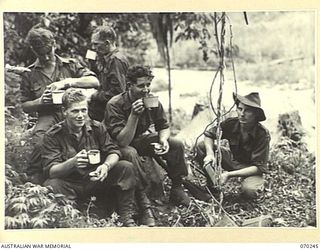 FARIA VALLEY, NEW GUINEA, 1944-02-09. MEMBERS OF THE 2/10TH INFANTRY BATTALION EATING OPERATIONAL RATIONS DURING THE FOUR-HOUR TREK FROM KANKIRYO TO GUY'S POST