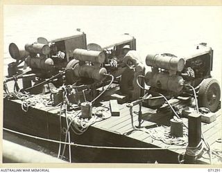 PORT MORESBY, PAPUA, 1944-03-21. SX8649 SAPPER K. HARRIS (1), OF THE 2/16TH FIELD COMPANY, ROYAL AUSTRALIAN ENGINEERS, ALONGSIDE A COMPRESSOR PLANT ON A PONTOON. THE PLANT IS USED FOR DRILLS ON A ..