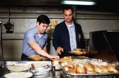 Crewmen selects food while in the mess line aboard the amphibious assault ship USS GUAM (LPH 9). The ship is participating in operations off the coast of Lebanon