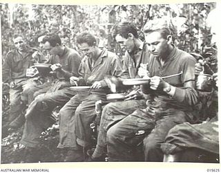 1943-08-30. NEW GUINEA. STAFF OF A U.S. PORTABLE HOSPITAL ON MOUNT TAMBU HAVING BREAKFAST. THEY WERE WITHIN 600 YARDS OF THE JAPANESE POSITIONS (NEGATIVE BY H. DICK)