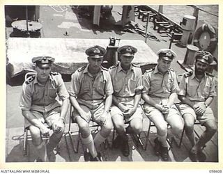 RABAUL, NEW BRITAIN. 1945-10-30. OFFICERS ON THE QUARTERDECK OF HMAS KIAMA. IDENTIFIED PERSONNEL ARE:- SUB-LIEUTENANT N. SALTER (1); LIEUTENANT H.E. GODDEN (2); LIEUTENANT COMMANDER S.J. BENSON ..