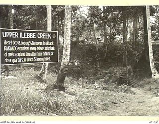 UPPER ILEBBE CREEK, FINSCHHAFEN AREA, NEW GUINEA, 1944-03-20. ONE OF MANY BATTLE SIGNS IN THE FINSCHHAFEN AREA, THIS SIGN RECORDS ACTIVITIES OF THE 2/13TH INFANTRY BATTALION IN THE MOVE TO ATTACK ..