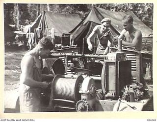 BOUGAINVILLE, 1945-07-16. MECHANICS OF 312 LIGHT AID DETACHMENT ATTACHED 29 INFANTRY BRIGADE, OVERHAULING A JAPANESE PRIME MOVER. USED TO HAUL ENEMY GUNS THREE WEEKS AGO IT WILL NOW BE USED TO HAUL ..