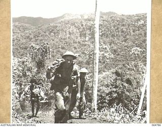 UBERI AREA, NEW GUINEA. 1943-12-19. NATIVE CARRIERS AND MEMBERS OF THE 2/9TH INFANTRY BATTALION AT GOLDIES CROSSING NEAR OWERS' CORNER PLAYING EXTRAS DURING THE FILMING OF THE FINAL OF THE FINAL ..