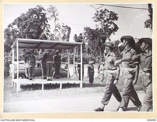 TOROKINA, BOUGAINVILLE. 1945-09-24. TROOPS OF B COMPANY, 24 INFANTRY BATTALION, 15 INFANTRY BRIGADE, SALUTING AS THEY PASS THE SALUTING BASE DURING THE MARCH PAST AT A PARADE HELD AT GLOUCESTER ..