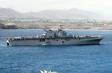 A starboard beam view of the amphibious assault ship USS BELLEAU WOOD (LHA-3) off the coast of the island of Kauai. The vessel is dispensing supplies to the island by landing craft and helicopter as part of Joint Task Force Garden Isle, a joint military disaster relief effort organized to provide assistance to residents of the region in the aftermath of Hurricane Iniki
