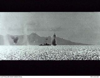 GUADALCANAL, SOLOMON ISLANDS, 1942-08-07. OFF TULAGI, JAPANESE AIRCRAFT DIVE BOMB THE DESTROYER USS MUGFORD. SHE WAS HIT IN THE STERN BY A MEDIUM BOMB KILLING TWENTY-ONE CREW