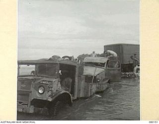 SONG RIVER, NEW GUINEA. 1944-06-27. A BOGGED AUSTRALIAN NEW GUINEA ADMINISTRATIVE UNIT "BLITZ BUGGY" CARRYING A MILITARY HISTORY PHOTOGRAPHER RECEIVES A PUSH FROM A UNITED STATES ARMY TRUCK DURING ..