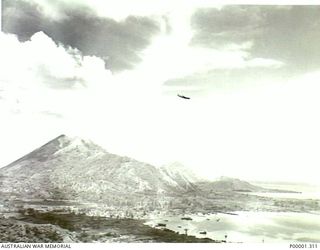 NEW BRITAIN, 1945-09. A LOCKHEED HUDSON AIRCRAFT PASSING OVER RABAUL AND SIMPSON HARBOUR. (RNZAF OFFICIAL PHOTOGRAPH.)