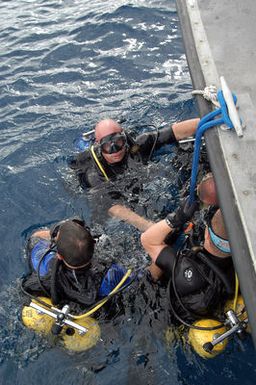 US Navy (USN) Mobile Diving and Salvage Unit (MDSU) 1, Detachment (DET) 3, members stand by on the surface, waiting for the rest of their team to enter the water. DET 3 is conducting Self Contained Underwater Breathing Apparatus (SCUBA) training on the 178-foot Sea Tiger, a sunken Japanese freighter, located in 120 feet below off Oahu's south shore