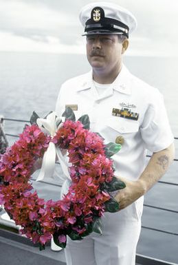 MCPO Charles Cartwright prepares to commit a wreath to the sea in memory of the servicemen who lost their lives in the Solomon Islands Campaign during World War II. The ceremony is taking place aboard the tank landing ship USS RACINE (LST-1191) at Iron Bottom Sound off the coast of Guadalcanal