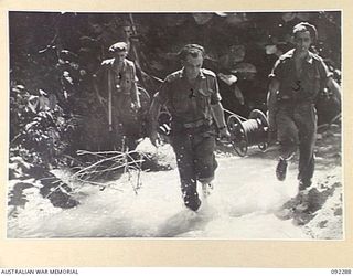 BOUGAINVILLE. 1945-05-17. SIGNALLERS LAYING CABLE ACROSS THE HUDA RIVER DURING THE ADVANCE OF C COMPANY, 57/60 INFANTRY BATTALION ALONG COMMANDO ROAD. IDENTIFIED PERSONNEL ARE:- PRIVATE W.J. SHARPE ..