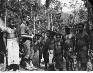 RYAN'S POST, FINISTERRE RANGE, NEW GUINEA, 1944-02-15. NX78344 SERGEANT S.G. ARMSTRONG, A MEMBER OF THE AUSTRALIAN NEW GUINEA ADMINISTRATIVE UNIT GIVES ORDERS TO THE NATIVE CARRIER LINE BEFORE THEY ..