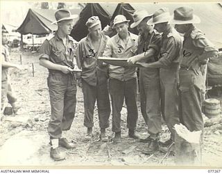 BOUGAINVILLE ISLAND. 1944-11-24. AUSTRALIAN ARMY OFFICERS BEING BRIEFED BY AMERICAN ARMY OFFICERS PRIOR TO THE AUSTRALIANS TAKING OVER THE FRONT LINE POSITIONS OCCUPIED BY THE AMERICANS ON THE LEFT ..