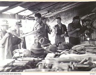 MADANG, NEW GUINEA. 1944-08-15. STAFF OF THE COMPANY QUARTERMASTER'S STORE ISSUING CLOTHING TO PERSONNEL OF THE 165TH GENERAL TRANSPORT COMPANY. IDENTIFIED PERSONNEL ARE:- VX83540 DRIVER V. BAZELEY ..