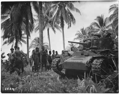 Locals taking an interest in a tank, Nissan Island, Papua New Guinea, during World War 2