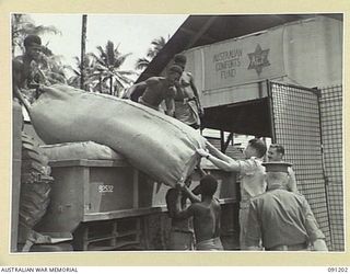 JACQUINOT BAY, NEW BRITAIN. 1945-04-27. A TRUCK LOAD OF MATTRESSES FOR DISTRIBUTION TO CASUALTY CLEARING STATIONS AND HOSPITALS BEING CHECKED BY CAPTAIN PARKER, COMFORTS FUND COMMISSIONER, AT 5 ..