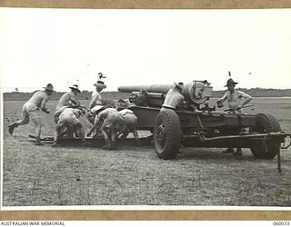 LYTTON, QLD. 1943-11-11. GUN DRILL AT T AUSTRALIAN HEAVY BATTERY, 155MM. EQUIPMENT. PERSONNEL ARE TRAINED HERE TO TAKE OVER FORTRESS AREAS IN NEW GUINEA. SHOWN ARE: GUNNER HAWKES (1); BOMBARDIER W. ..