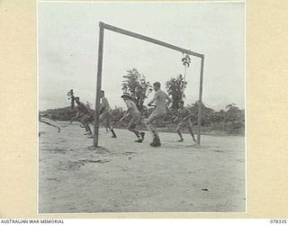 TOROKINA, BOUGAINVILLE ISLAND. 1945-01-13. A HOCKEY MATCH IN PROGRESS BETWEEN TEAMS FROM HEADQUARTERS, 2ND AUSTRALIAN CORPS AND THE ROYAL NEW ZEALAND AIR FORCE ON THE PIVA AIRSTRIP