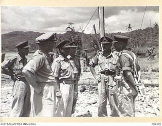 RABAUL, NEW BRITAIN. 1945-09-10. LIEUTENANT GENERAL K.W. EATHER, GENERAL OFFICER COMMANDING 11 DIVISION, CONFERRING WITH BRIGADIER C.R.V. EDGAR, COMMANDER 4 INFANTRY BRIGADE AND STAFF OFFICERS OF ..