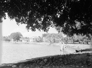 [A woman standing by a body of water]
